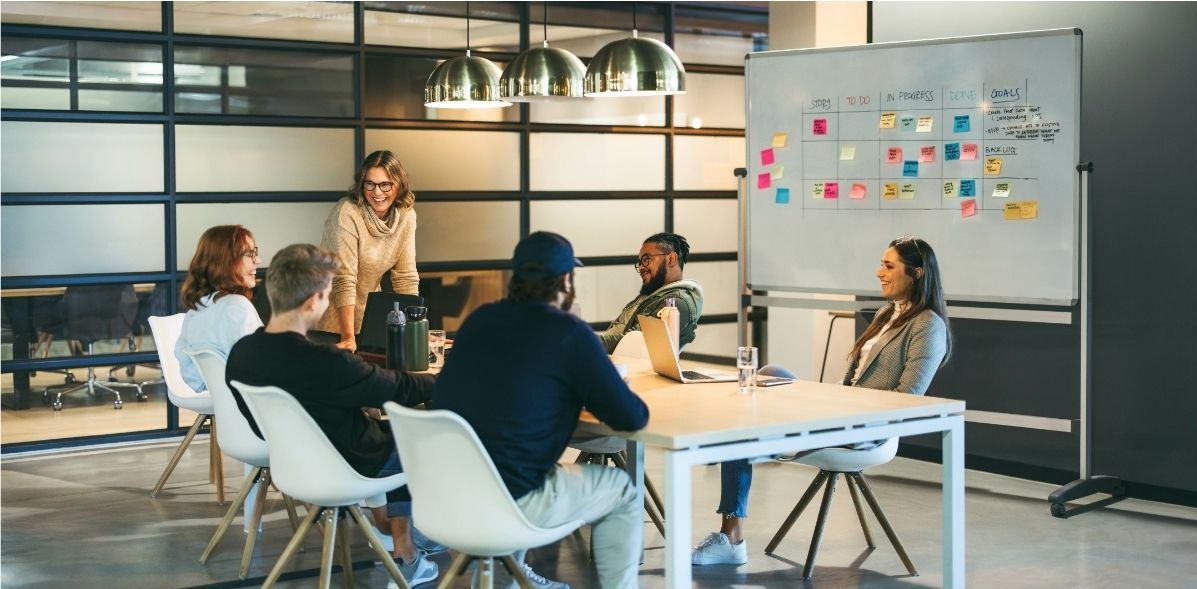 A group of people are sitting around a table having a meeting.