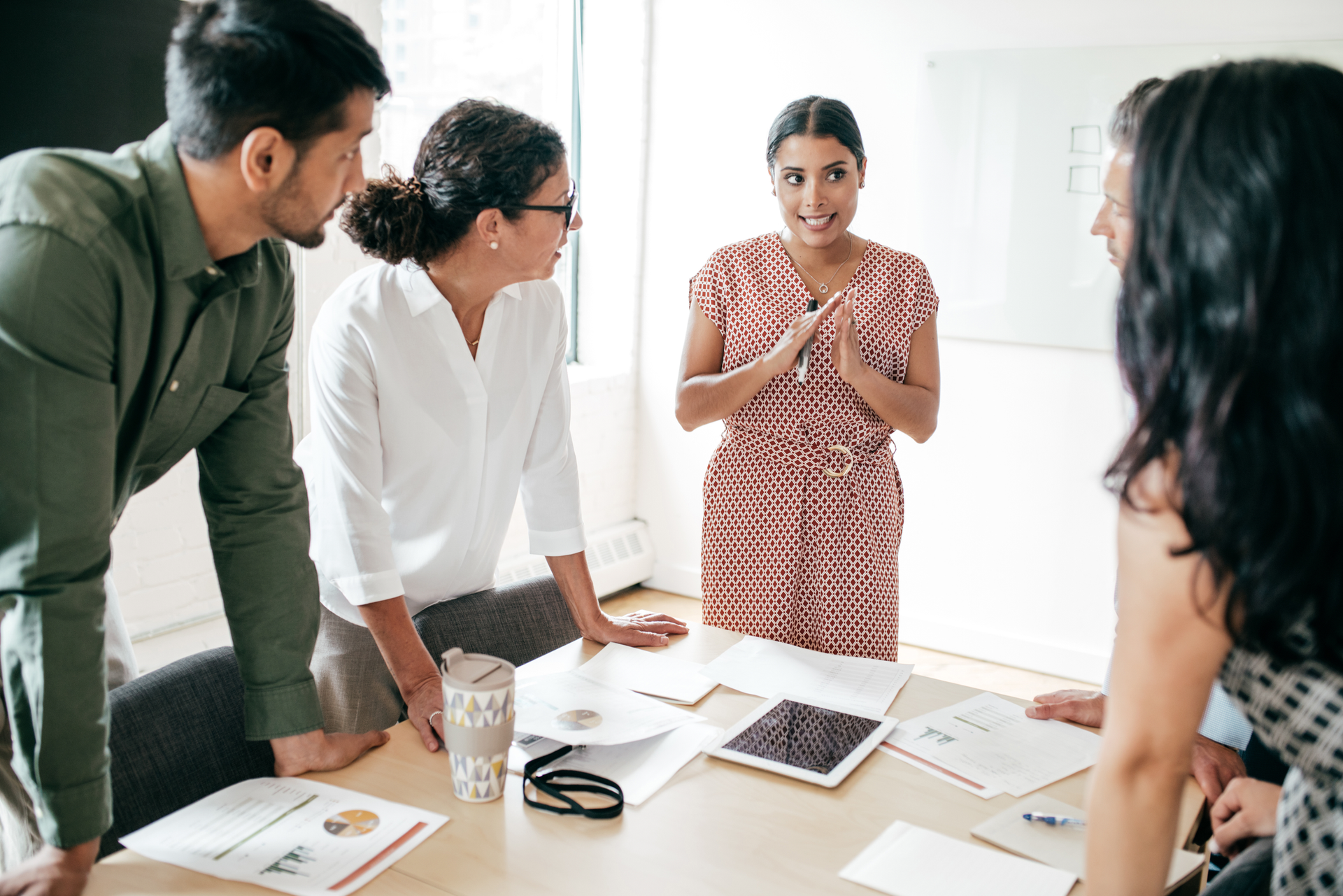 A group of people are sitting around a table having a meeting.