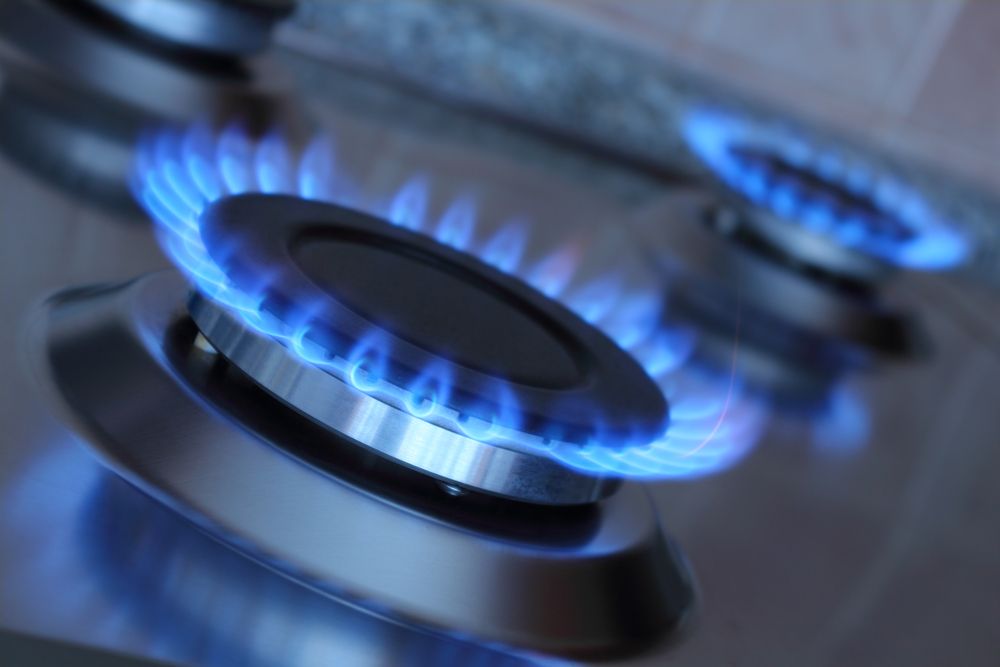 A gas stove with two lit burners.