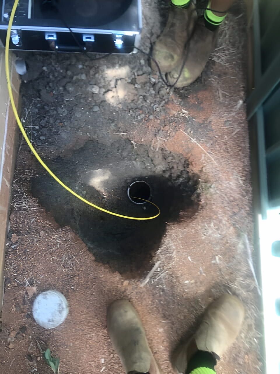 A Person Is Standing Next To A Hole In The Ground — Nudges Plumbing In Dubbo, NSW