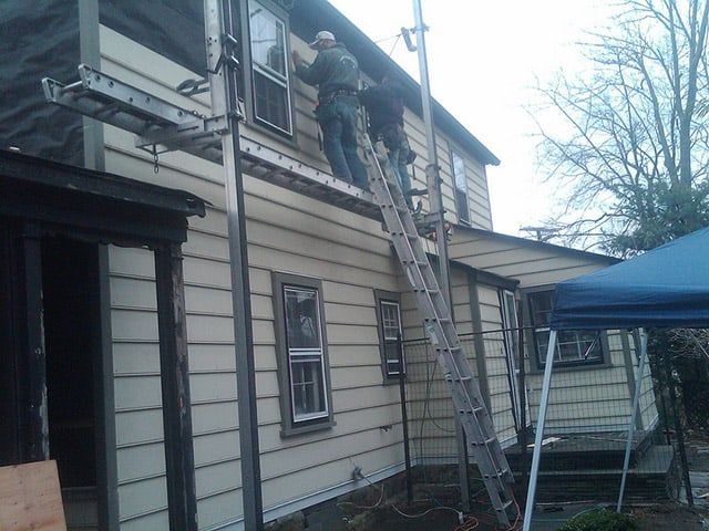 a man wearing a mask is standing on a ladder