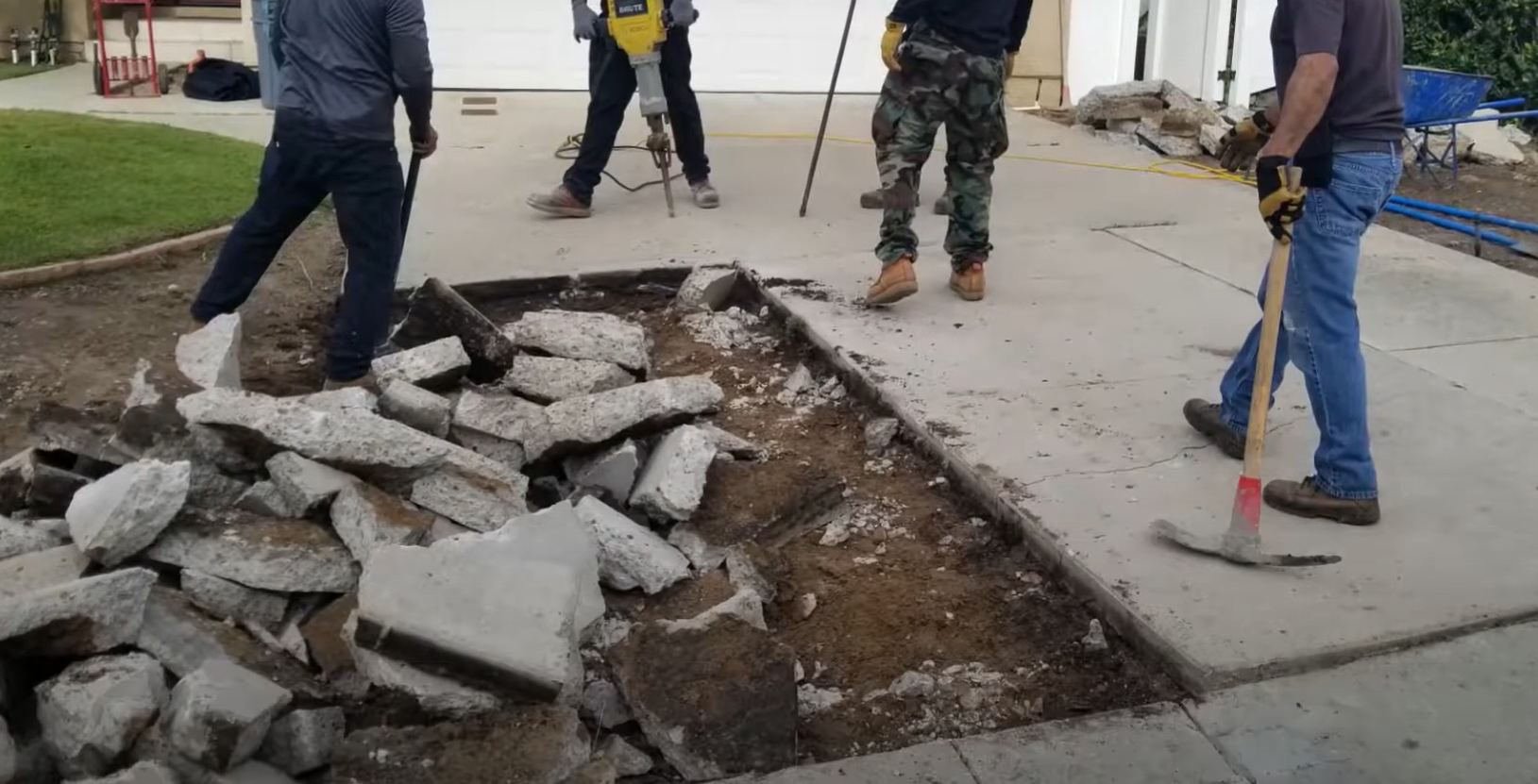 Concrete workers removing a damaged concrete driveway in Parkland, Washington