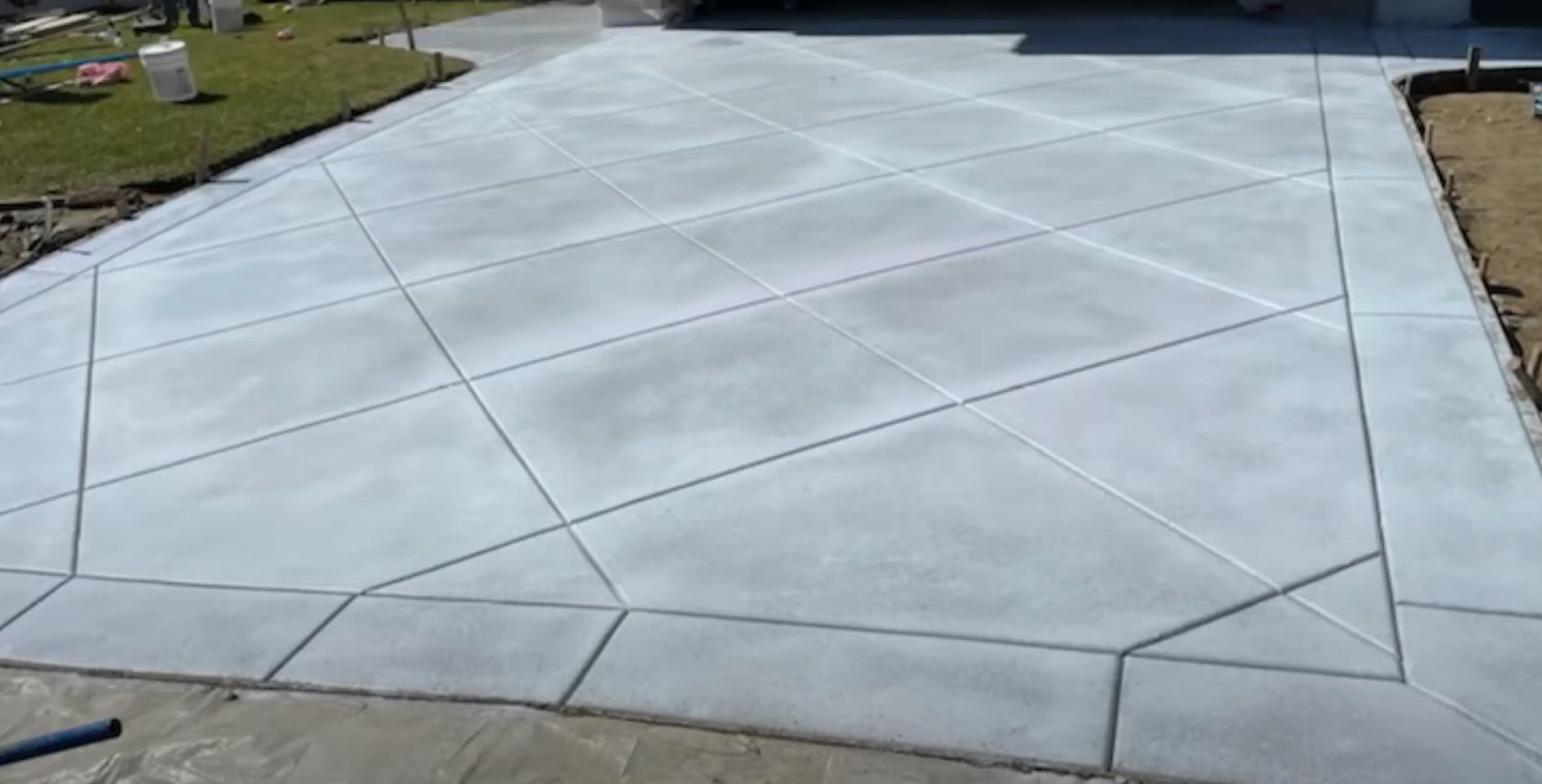 Newly installed and finished concrete driveway in Parkland, Washington with diagonal line design