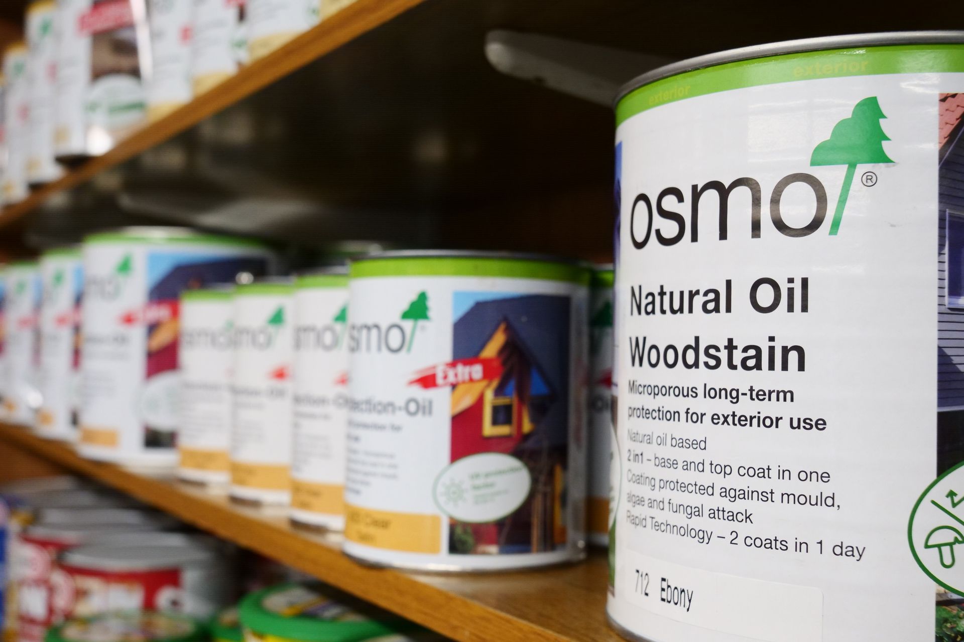 a shelf filled with cans of osmo natural oil woodstain