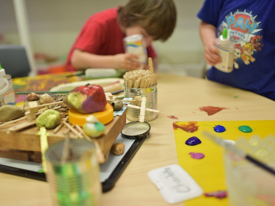 A boy wearing a paw patrol shirt sits at a table