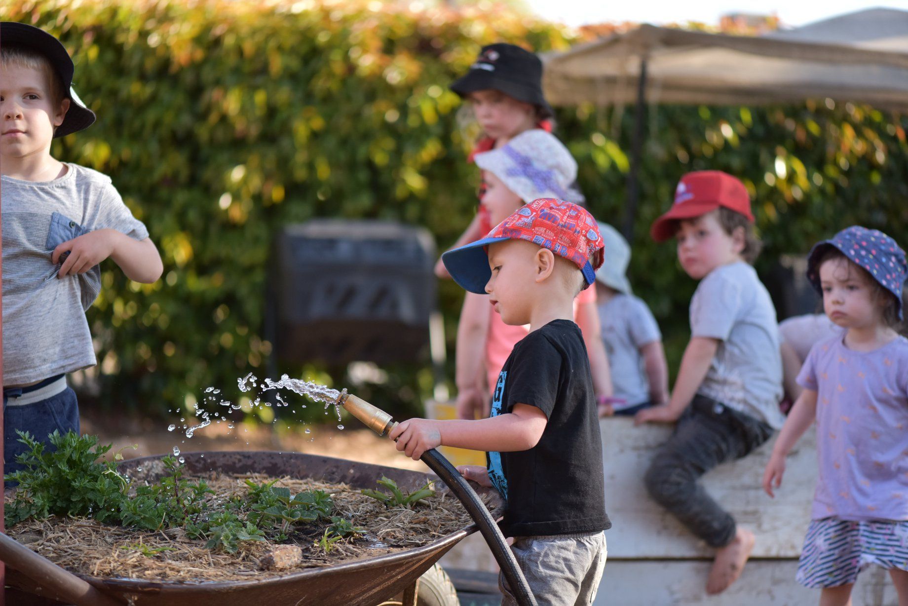 A playground with a lot of grass and a building in the background.