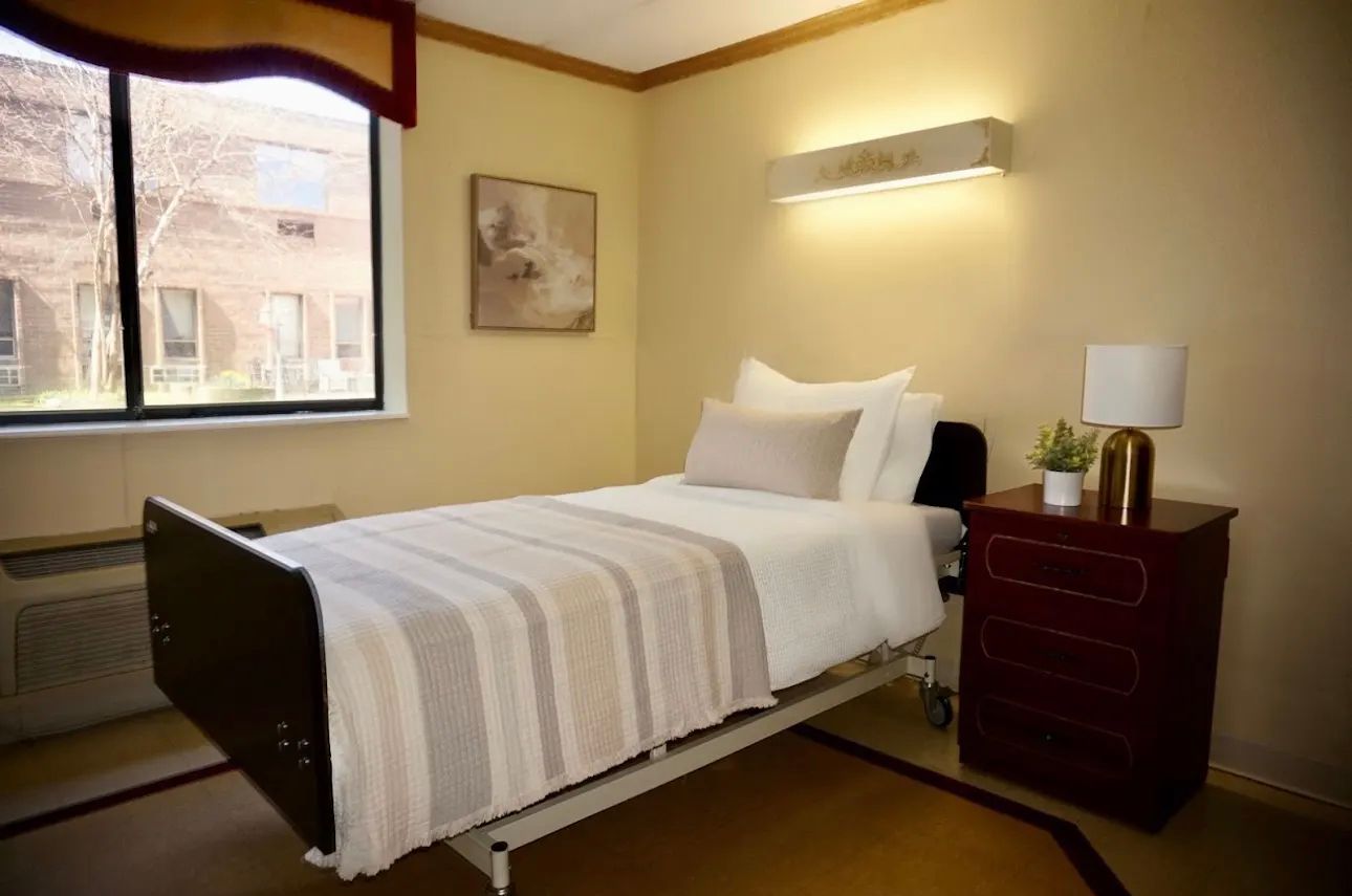 A hospital room with a bed and a window