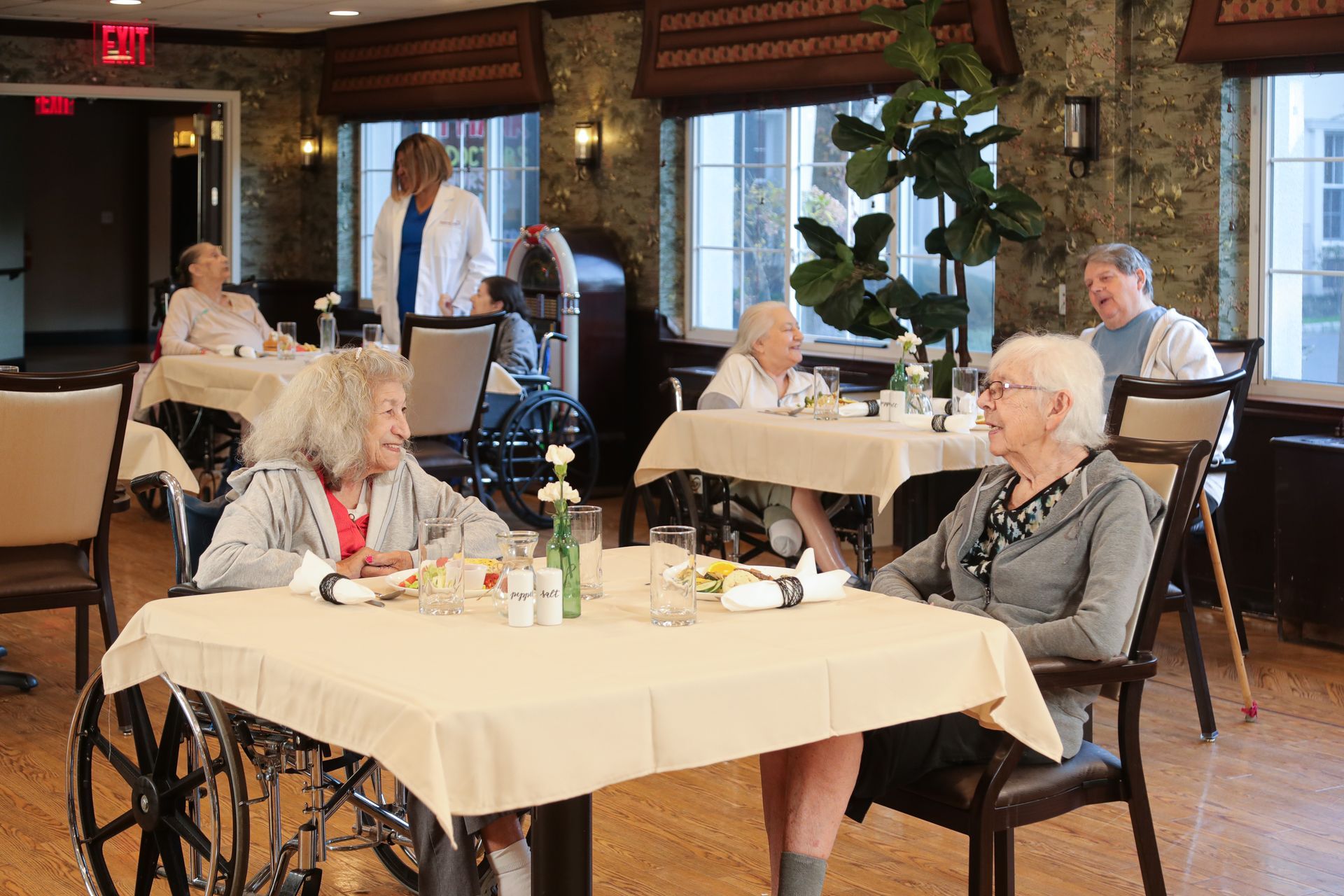A group of elderly people are sitting at tables in a dining room.