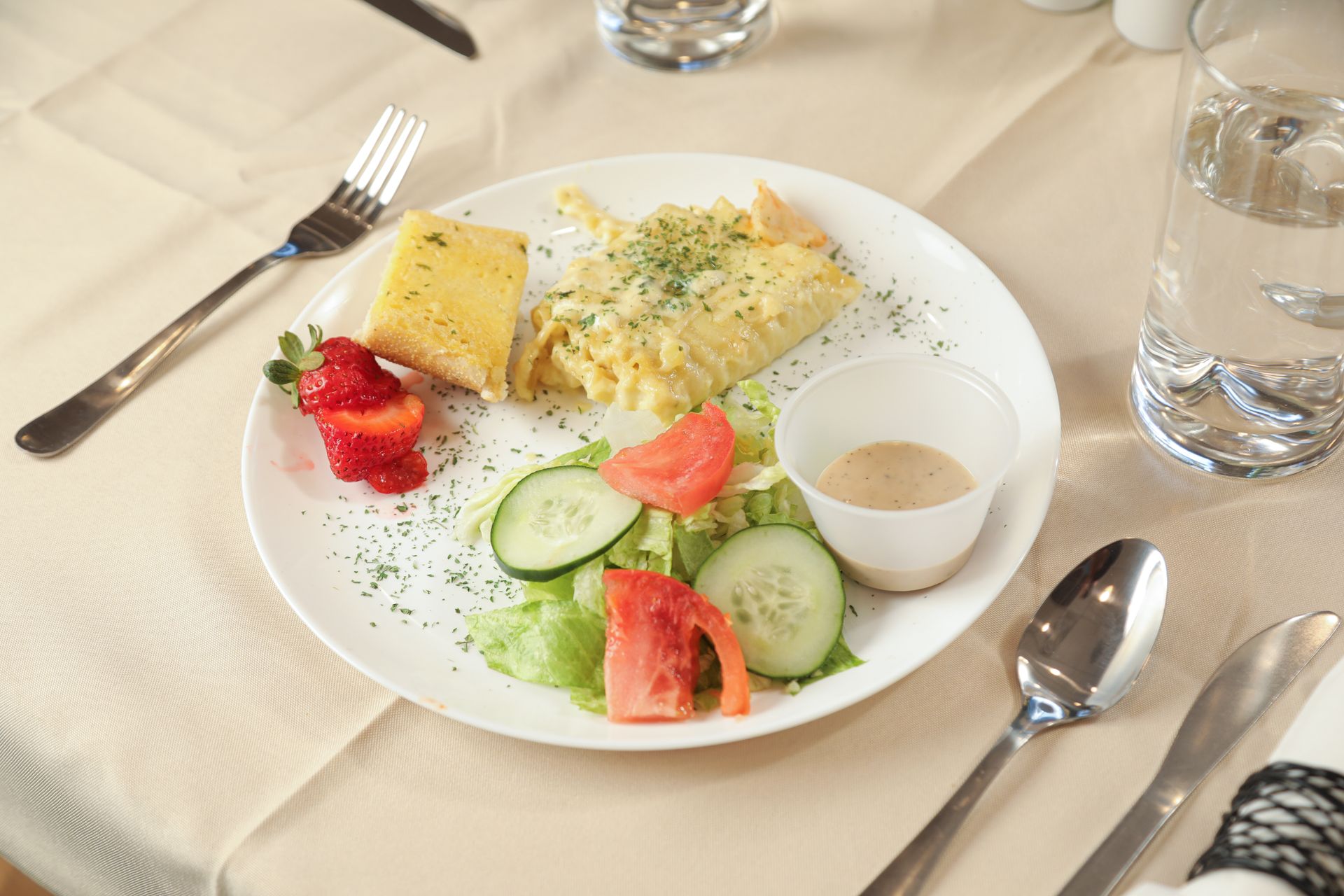 A plate of food on a table with a fork and spoon.