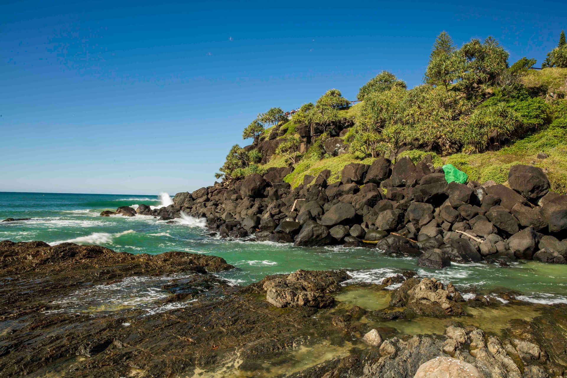 A Tent Is Sitting On A Rocky Cliff Overlooking The Ocean — Tweed Byron Recycling In Tweed Heads, NSW