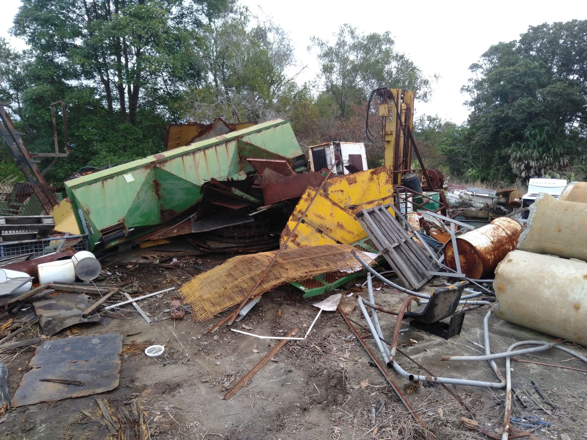 A Pile Of Scrap Metal Is Sitting On Top Of A Dirt Field — Tweed Byron Recycling In Tweed Heads, NSW