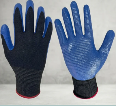 Un par de guantes de trabajo azules y negros con puños rojos, mostrados uno al lado del otro sobre un fondo claro.