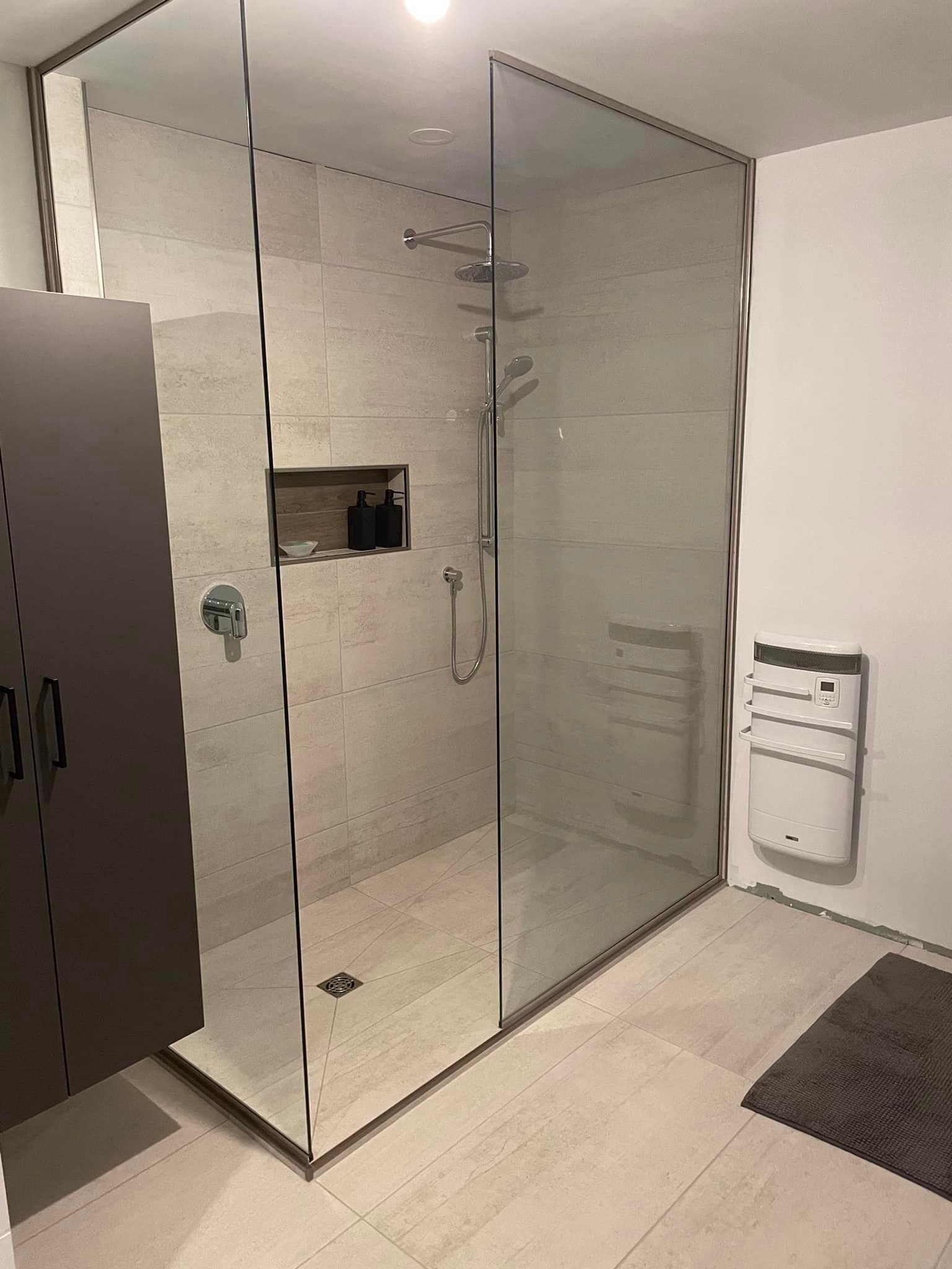 Une salle de bain avec douche à l'italienne avec porte vitrée.