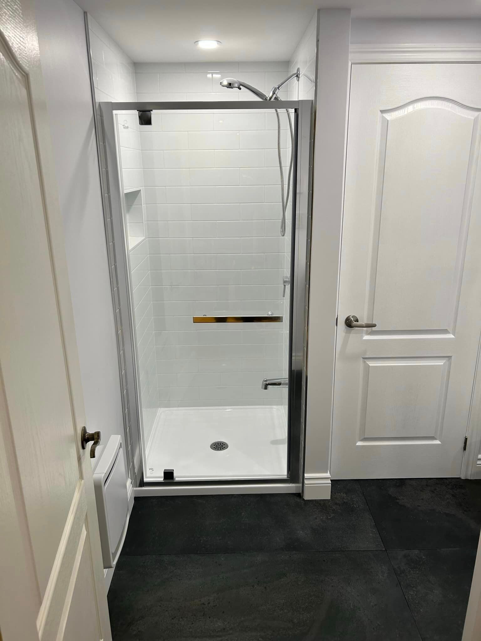 Une salle de bain avec une douche à l'italienne et une porte.