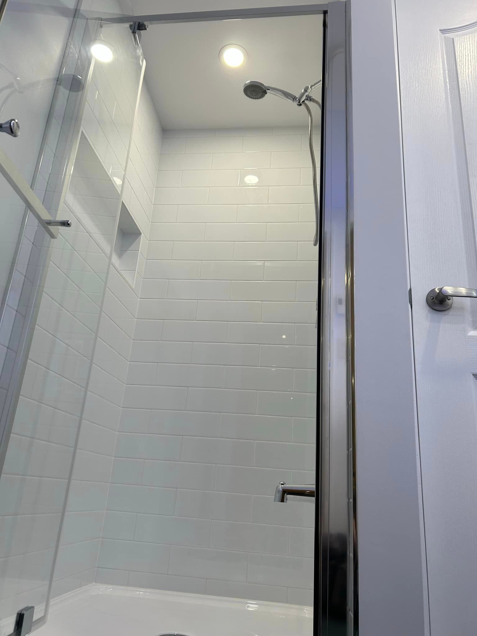 Une salle de bain avec une baignoire et une douche avec une porte vitrée.