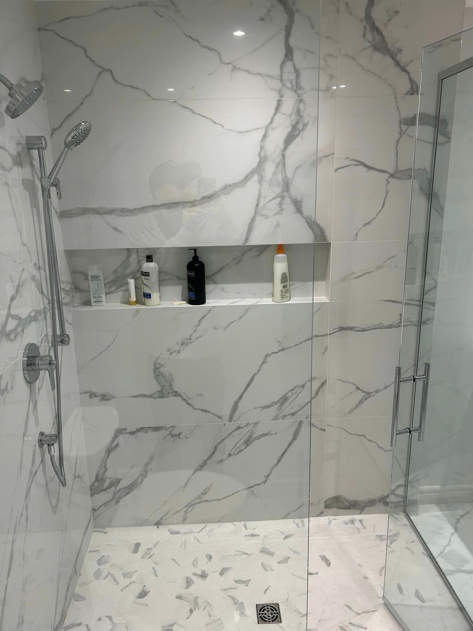 Une salle de bain avec carrelage en marbre et douche à l'italienne.