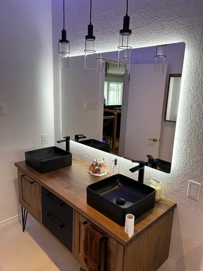 Une salle de bain avec deux lavabos et un grand miroir.