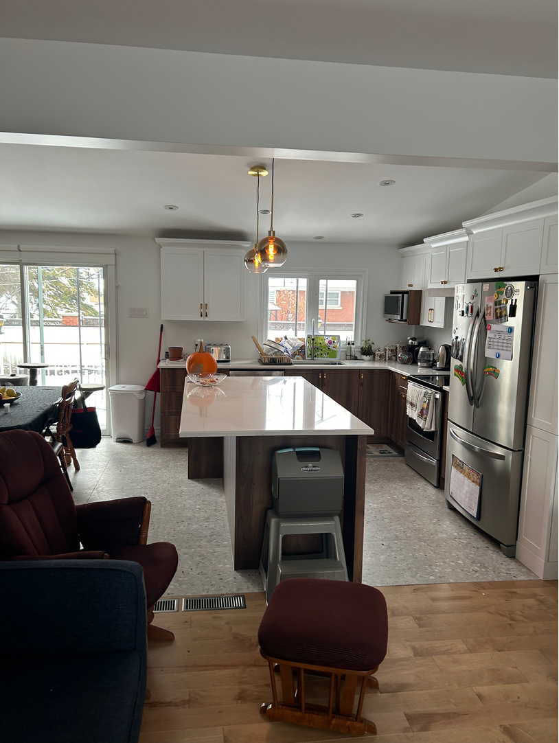 Une cuisine avec électroménagers en acier inoxydable et un grand îlot au milieu de la pièce.