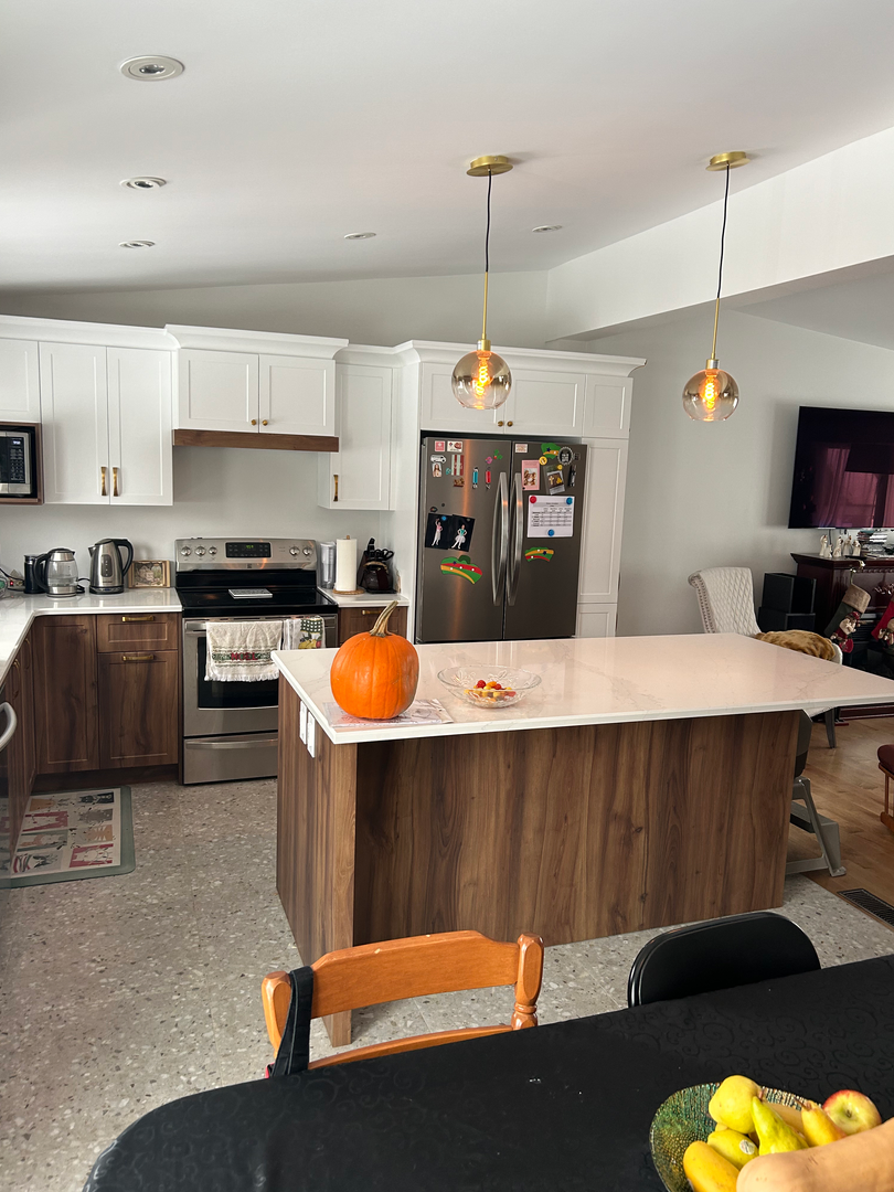 Une cuisine avec un grand îlot et une citrouille sur le comptoir.