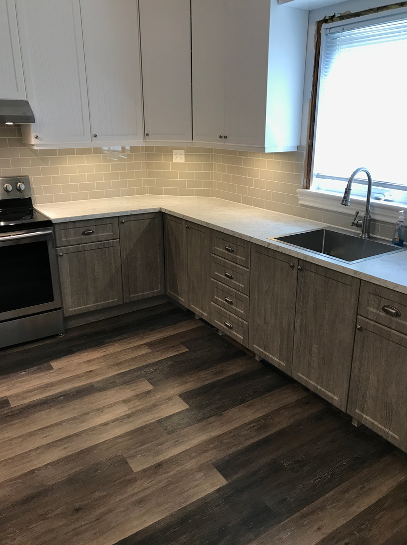 Une cuisine avec des armoires en bois, des appareils en acier inoxydable, un évier et une fenêtre.