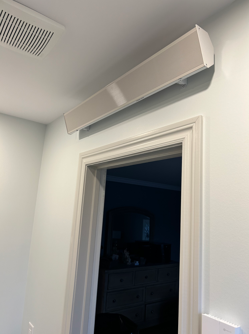 Il y a un haut-parleur suspendu au plafond au dessus de la porte.