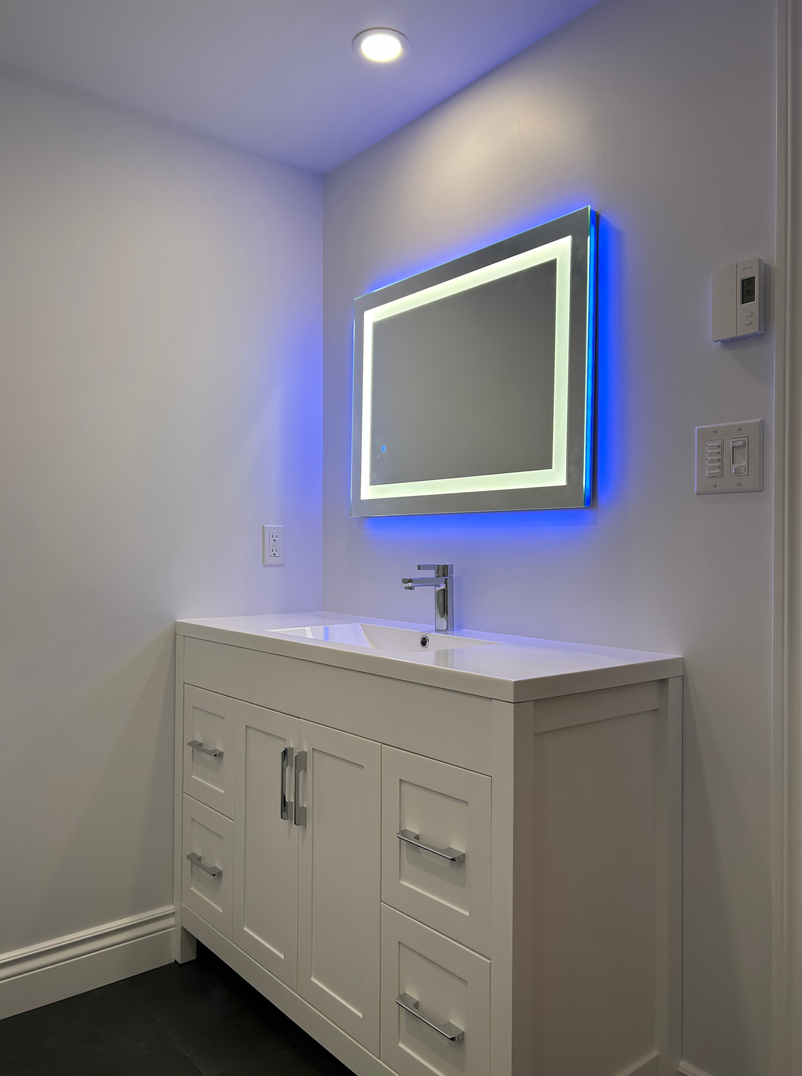 Une salle de bain avec un lavabo, un miroir et des lumières bleues.