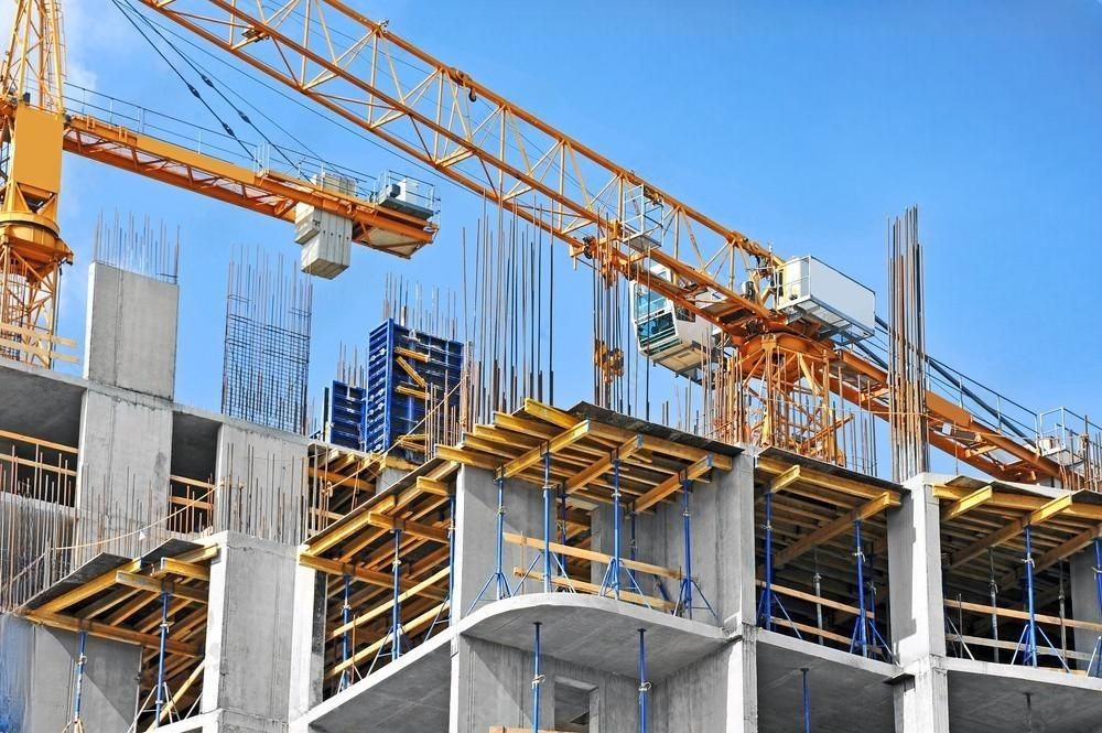 A large building is being built with cranes and scaffolding.