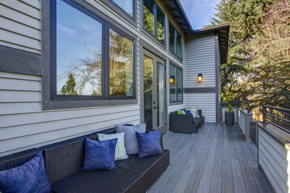 There is a large deck with a couch and chairs on it.