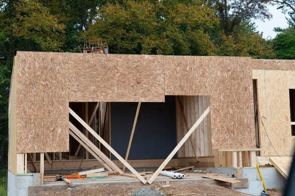 A house is being built with plywood and wooden beams.