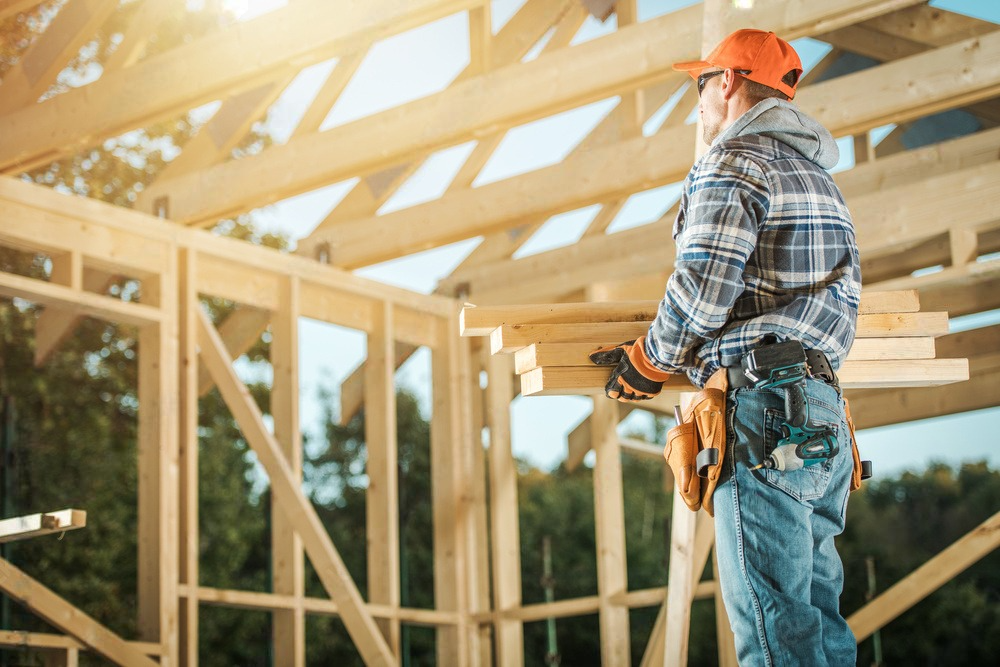 A construction worker is working on a wooden structure.