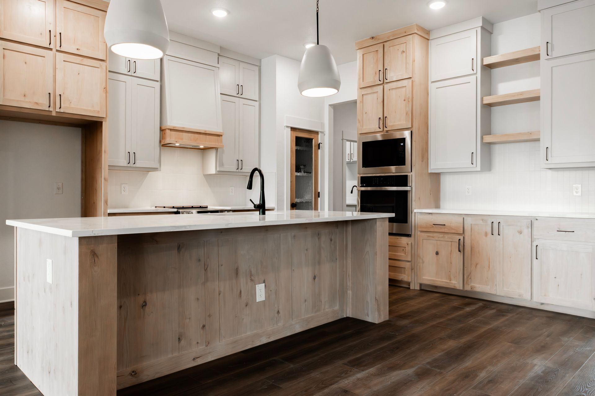 Modern kitchen with light wood cabinetry, white countertops, and an island.