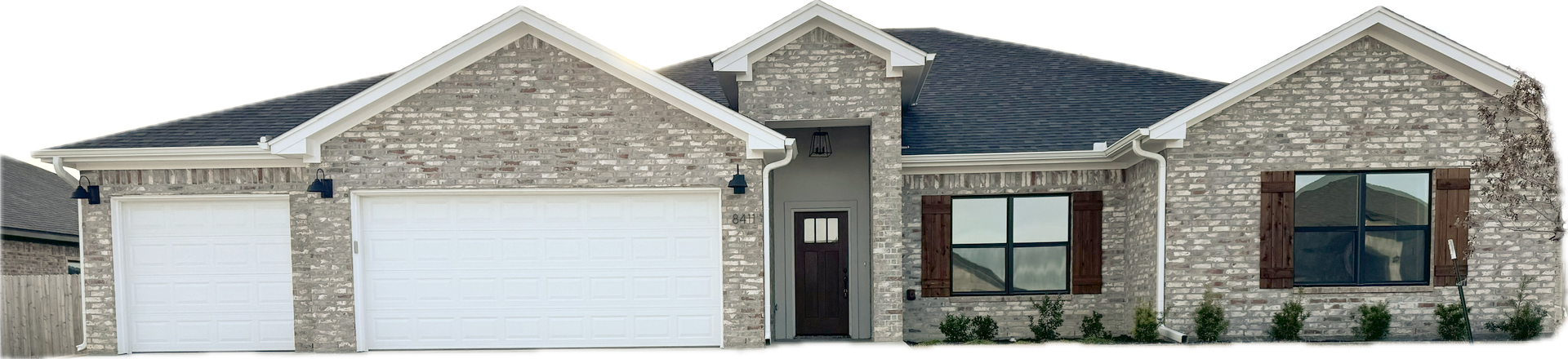 A stone-clad single-story house with a dark roof, two-car garage, and dark-colored front door.