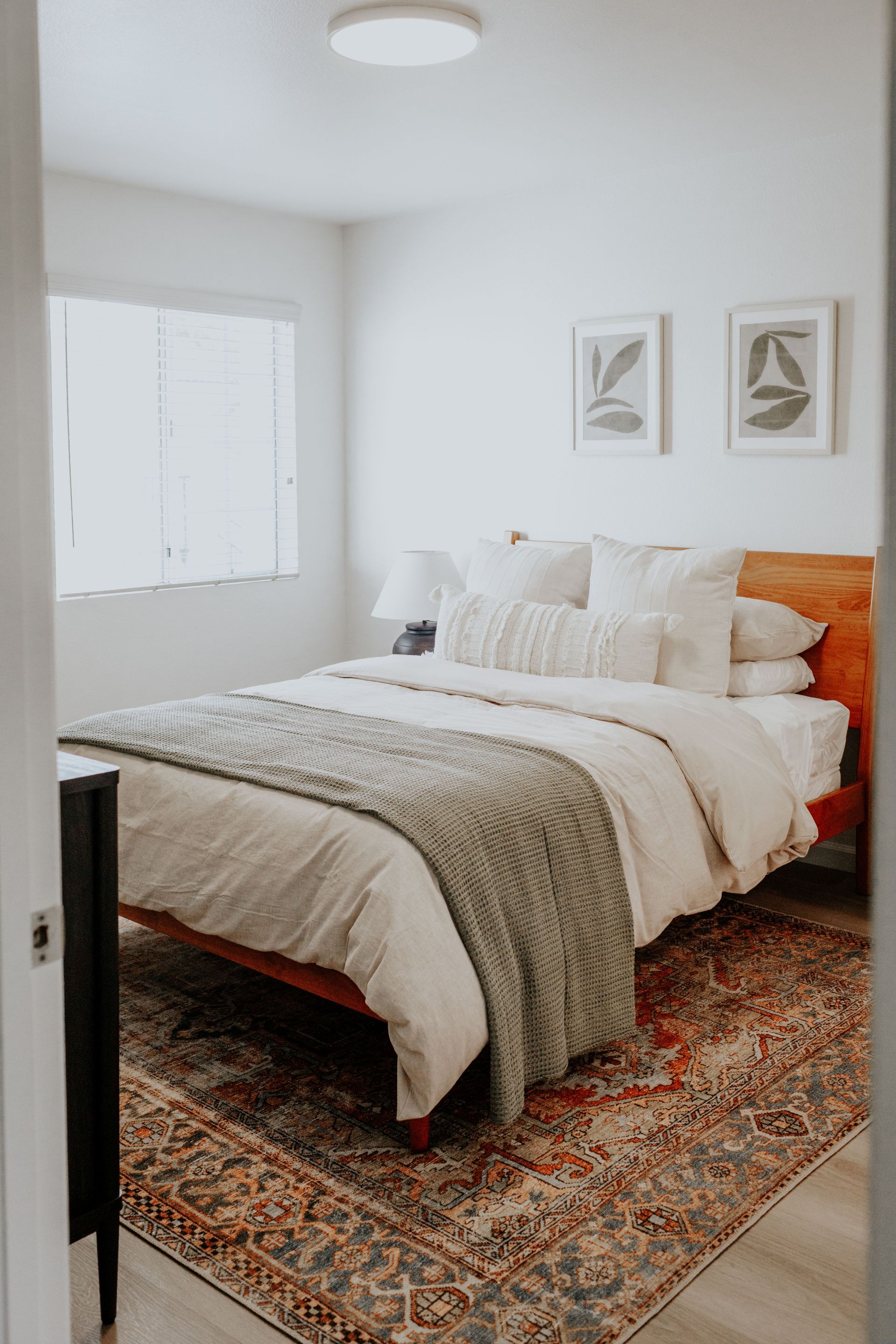 An empty living room with hardwood floors and stairs leading to the kitchen.