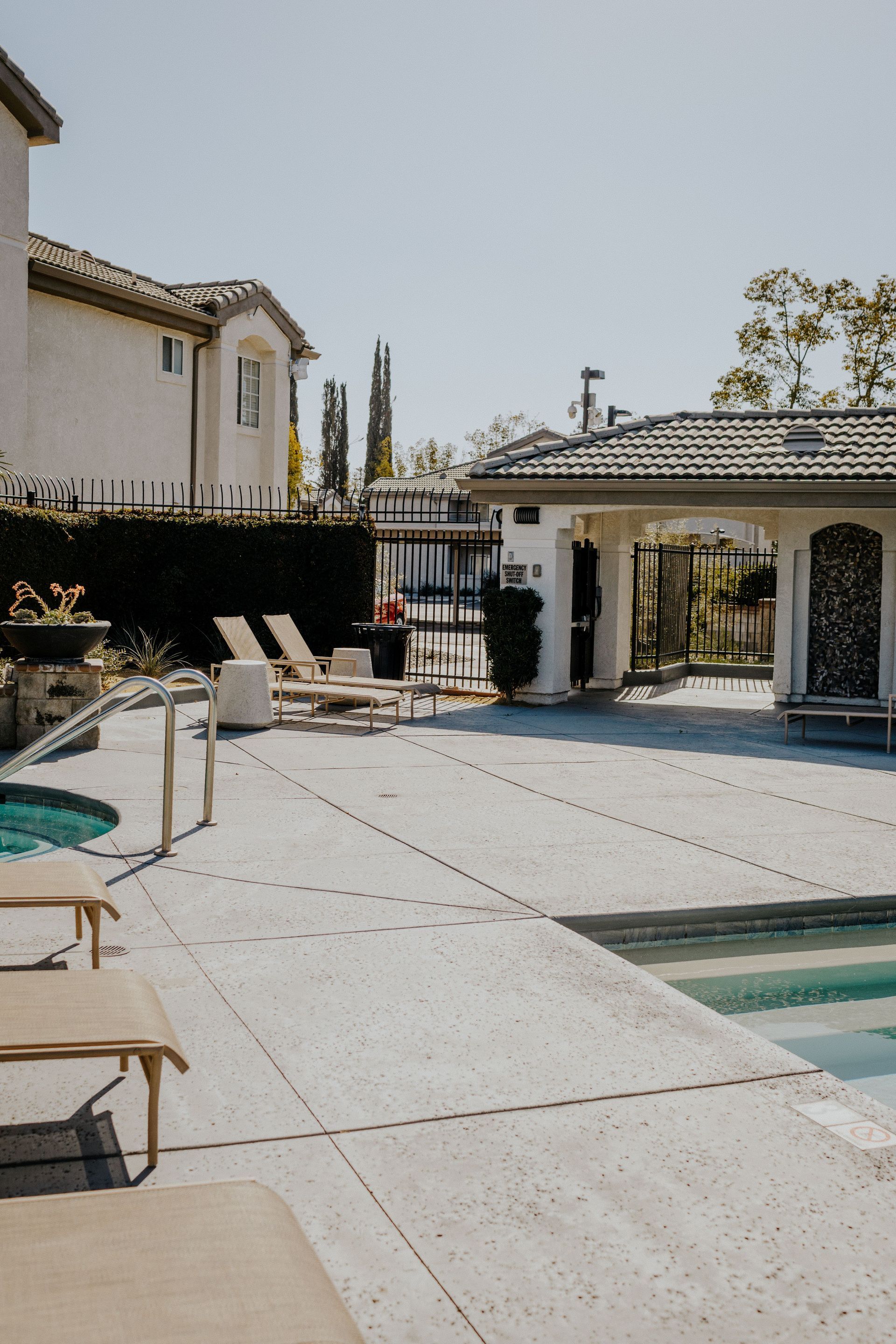 A large swimming pool surrounded by chairs and umbrellas