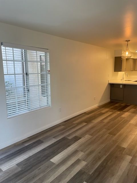 A living room with hardwood floors and a large window