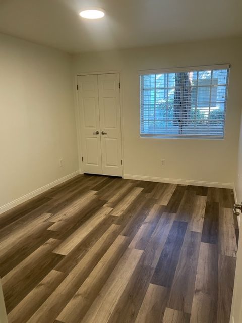 An empty room with hardwood floors and a window.