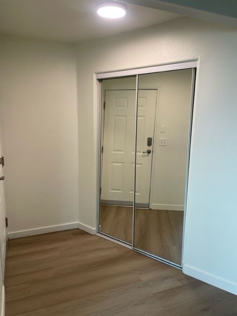 A room with a door and a mirrored door