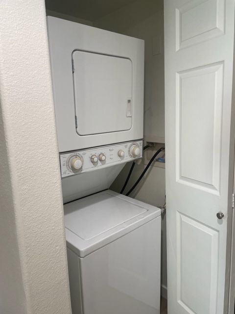 A washer and dryer are stacked on top of each other in a laundry room