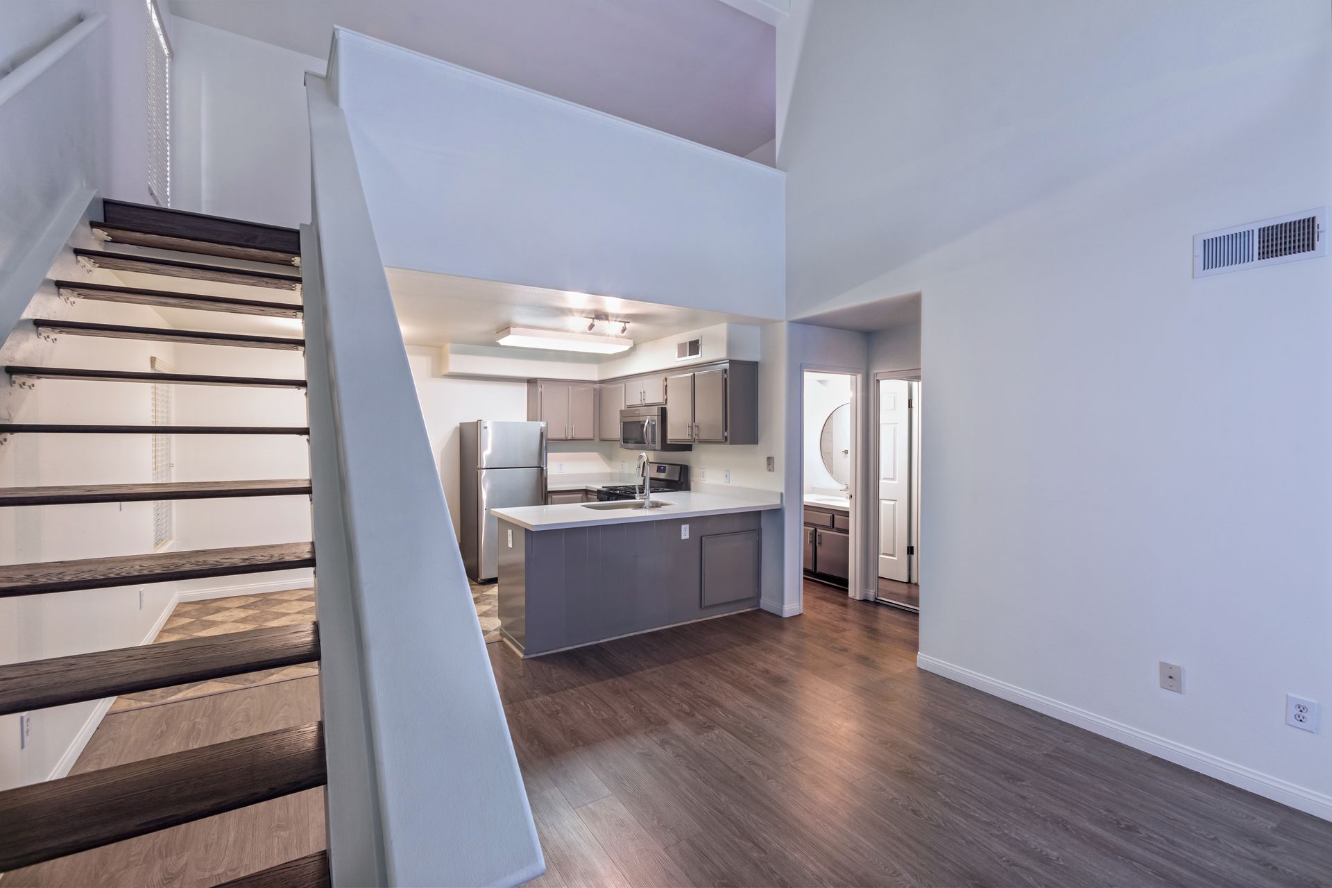 A kitchen with a staircase leading up to the second floor.