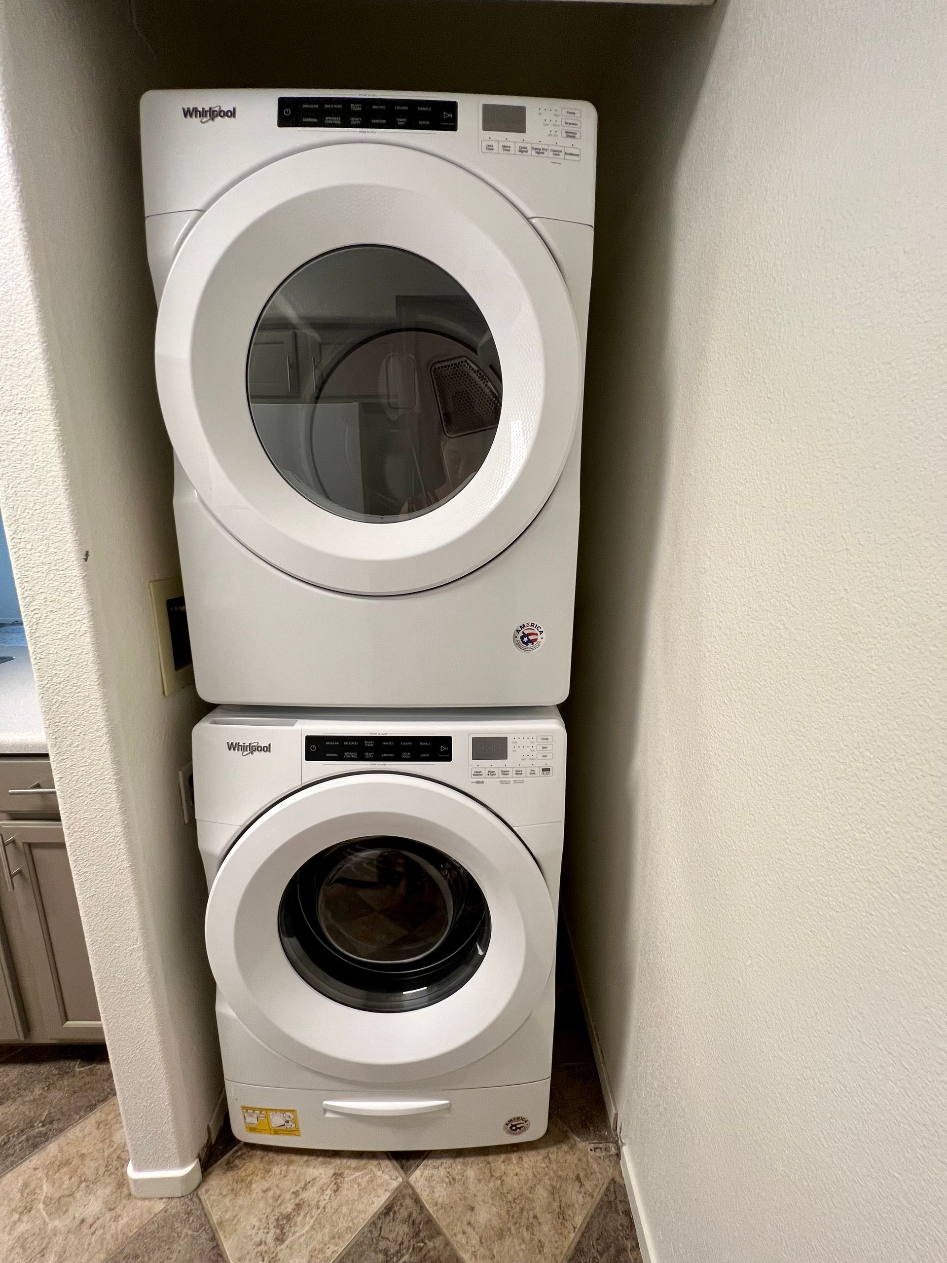 A washer and dryer are stacked on top of each other in a laundry room.