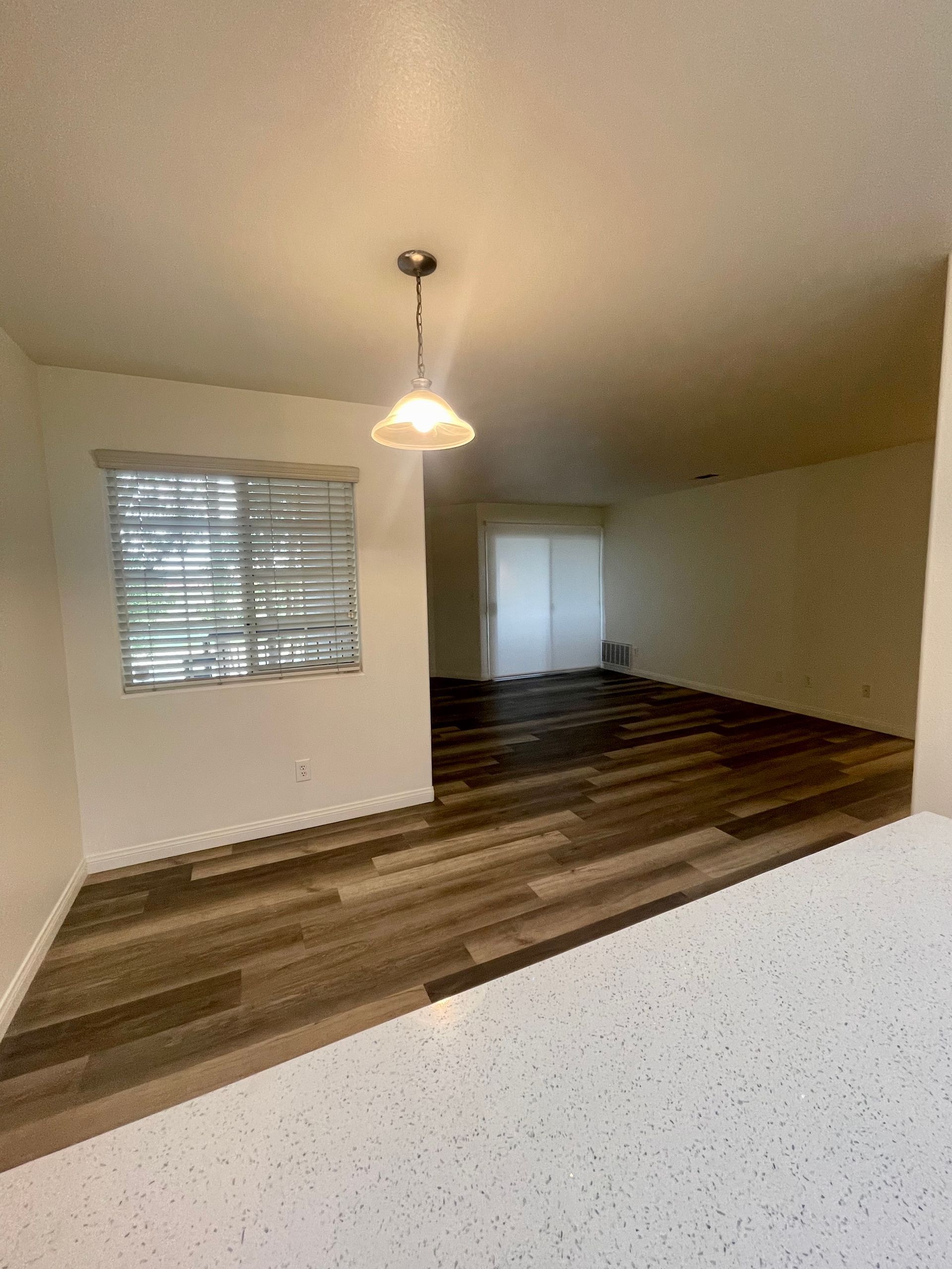 A living room with hardwood floors and a window.