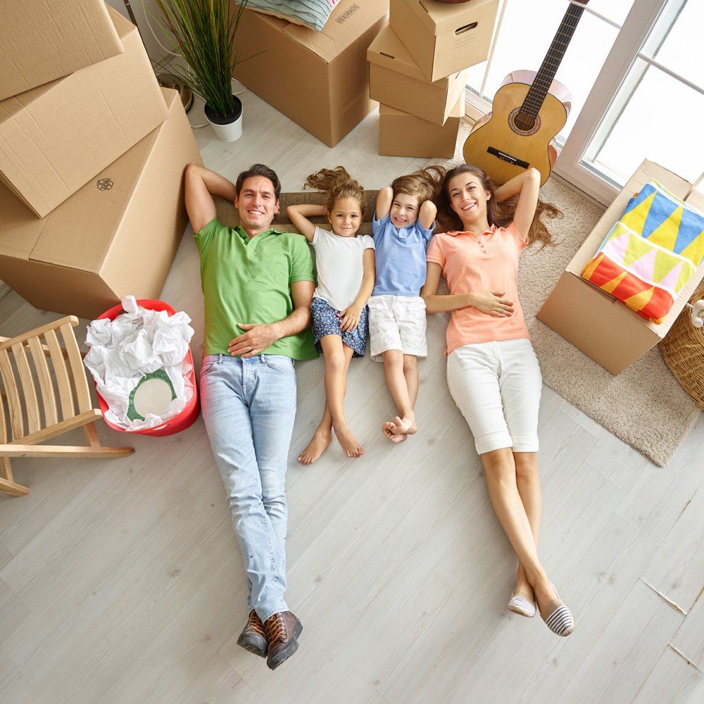 Family laying on ground moving in with boxes