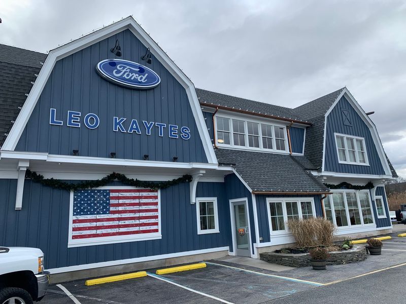 Blue Ford dealership building with American flag mural. 