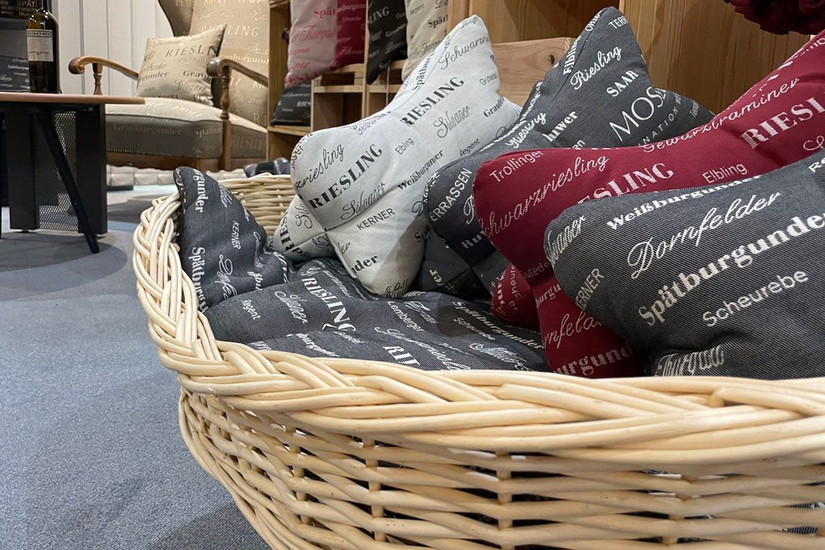 Ein Weidenkorb gefüllt mit verschiedenen Kissen