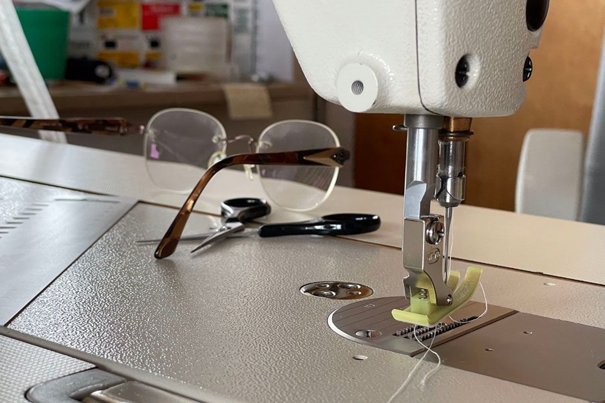 Eine Brille liegt auf einer Nähmaschine