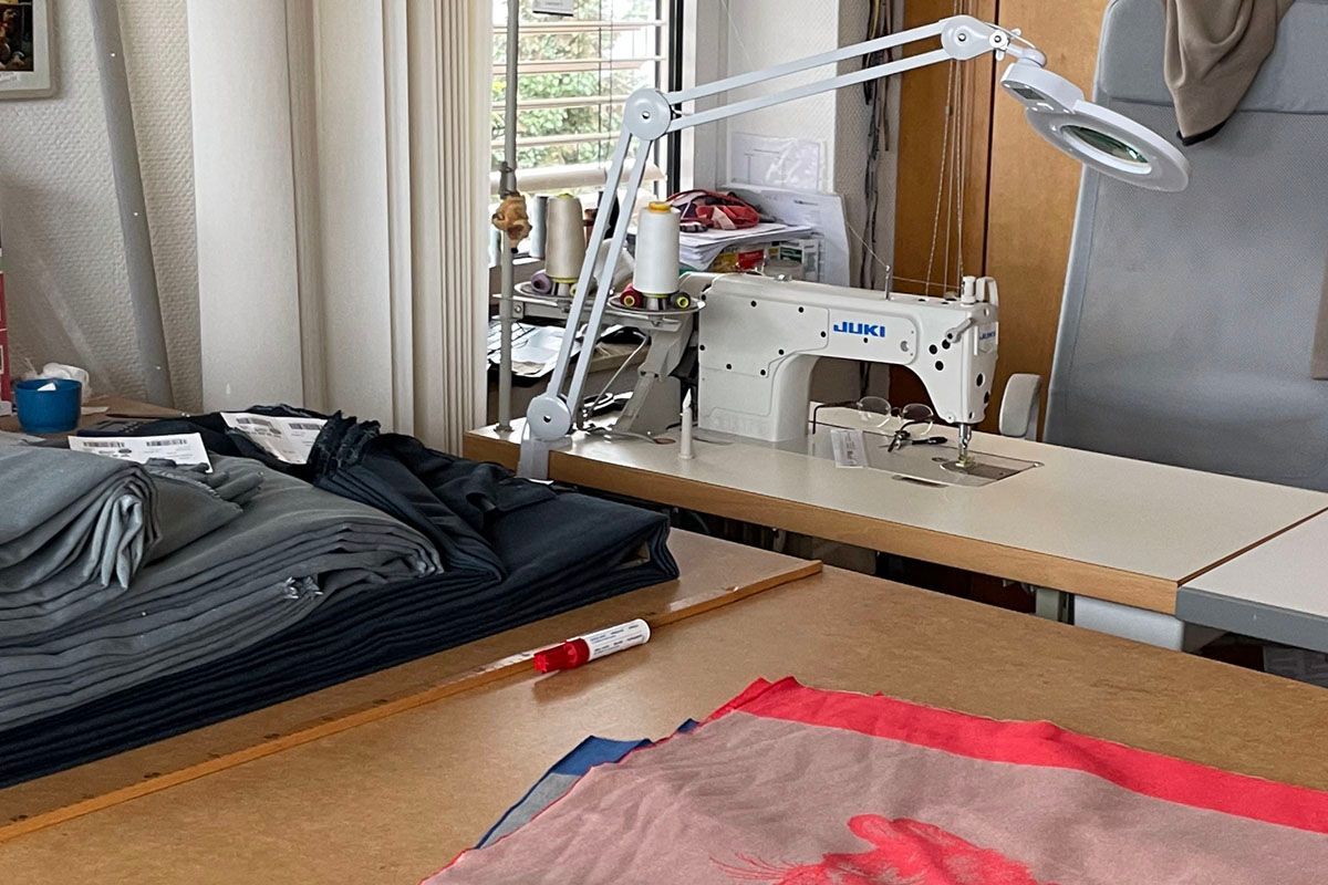 Auf einem Tisch neben einer Lampe steht eine Nähmaschine.