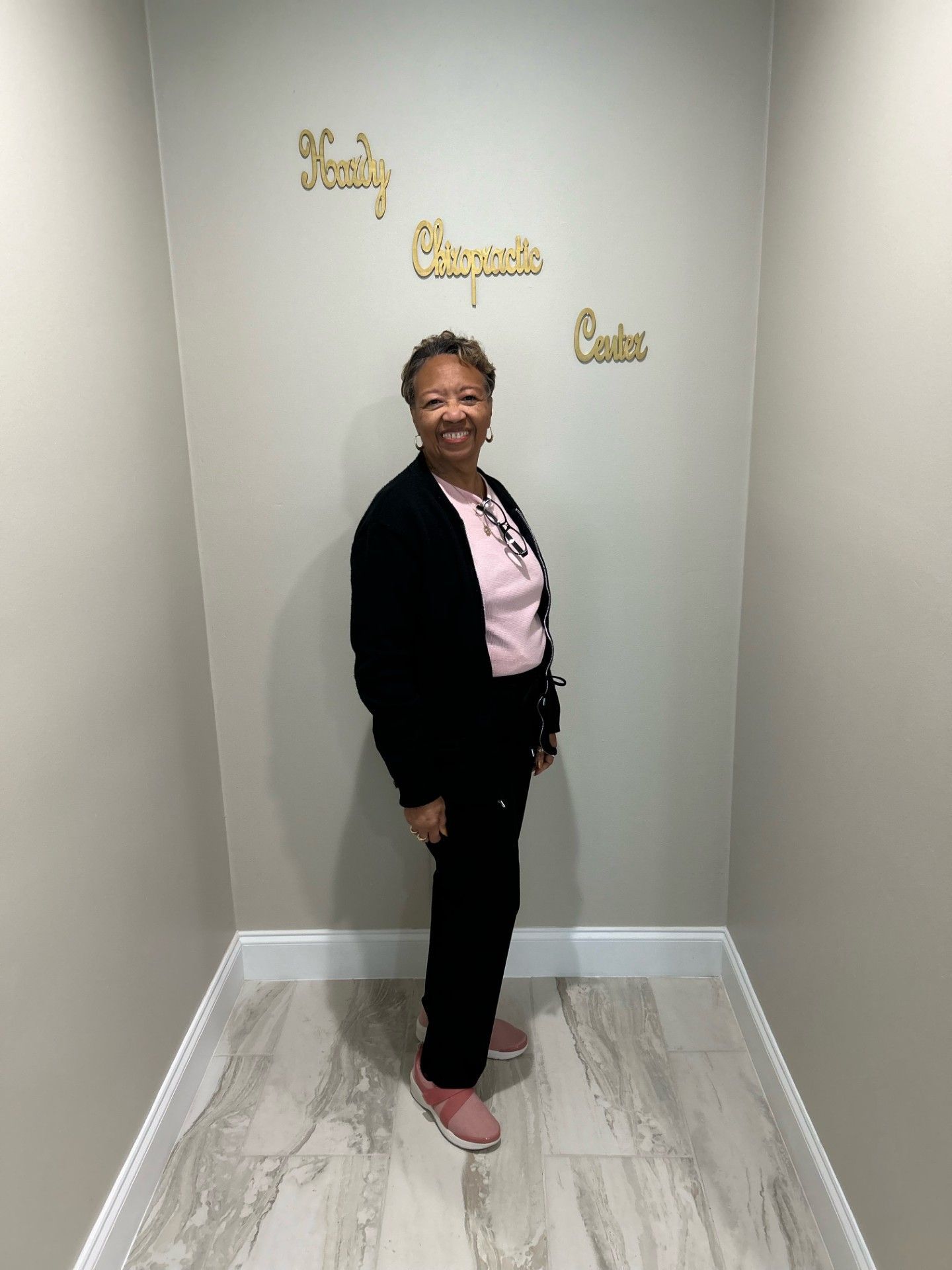 A woman is standing in front of a wall that says family chapel cakes