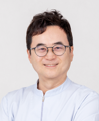 Smiling Asian doctor in a white coat.