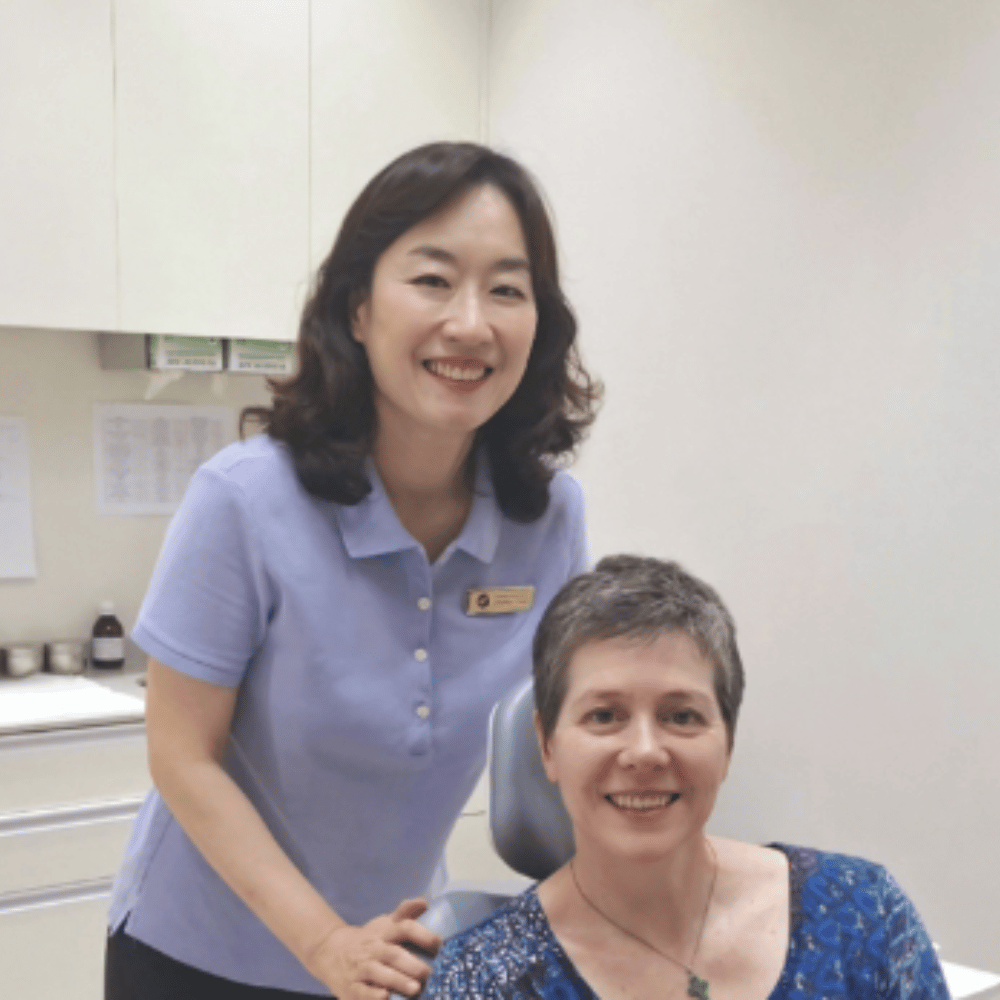 Dentist wearing mask and gloves working on a patient, indoors.