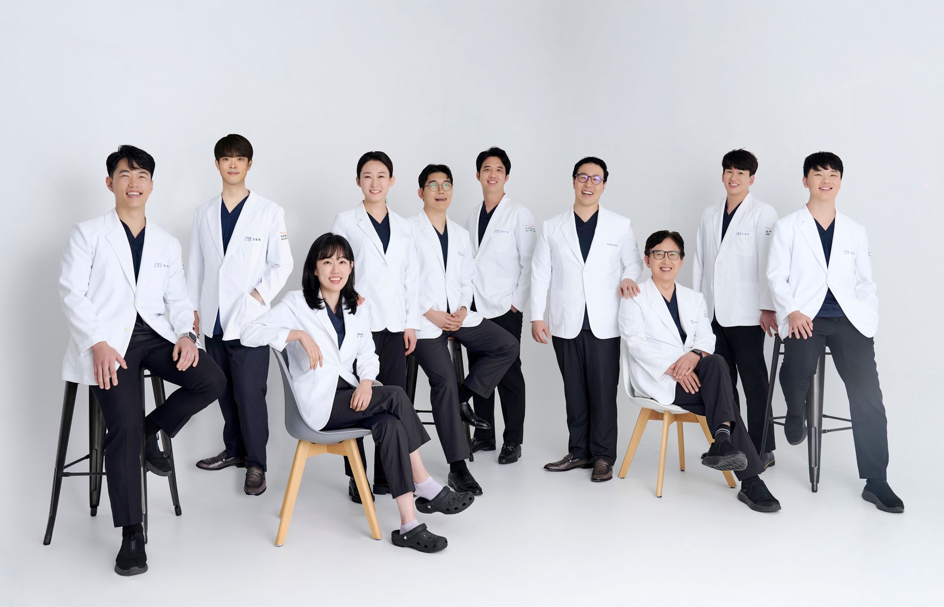 Group of Korean doctors in white coats smiling, posing for a photo.